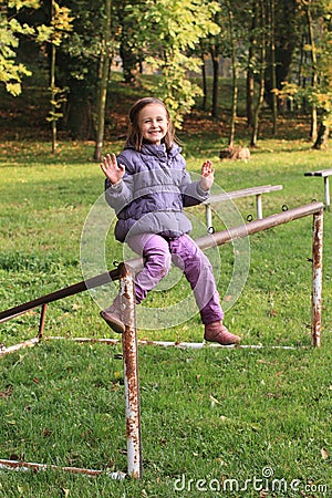 Smiling girl siting on football wicket