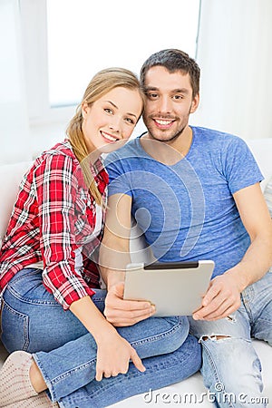 Smiling happy couple with tablet pc at home