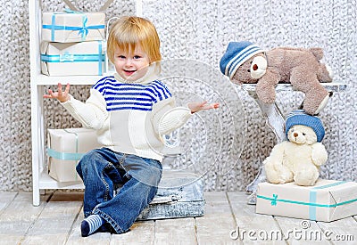 Smiling kid with gift boxes and teddy bears