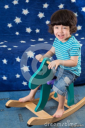 Smiling little boy have fun on a toy horse