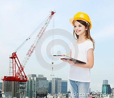 Smiling little girl in hardhat with clipboard