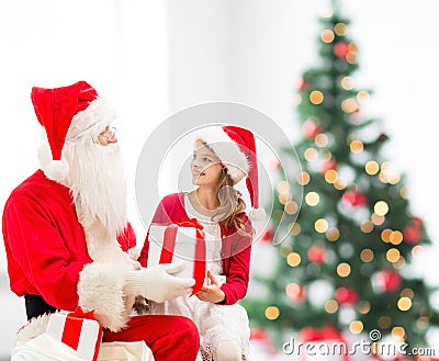 Smiling little girl with santa claus and gifts