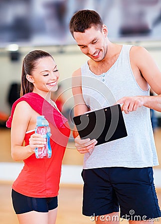 Smiling male trainer with woman in the gym