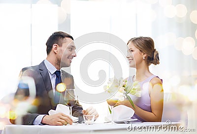 Smiling man giving flower bouquet at restaurant