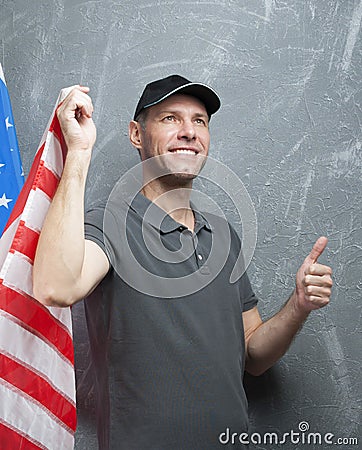 Smiling man in gray against background of USA flag