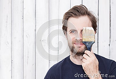 Smiling man with paint brush - renovation