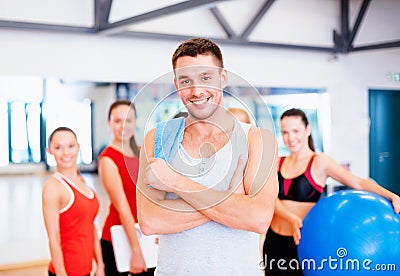Smiling man standing in front of the group in gym