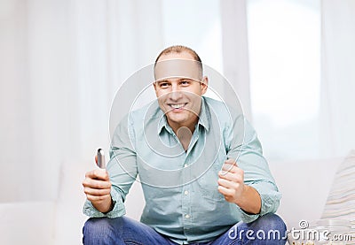 Smiling man watching sports at home