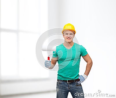 Smiling manual worker in helmet with paint roller