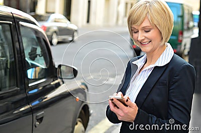 Smiling middle aged woman using cell phone