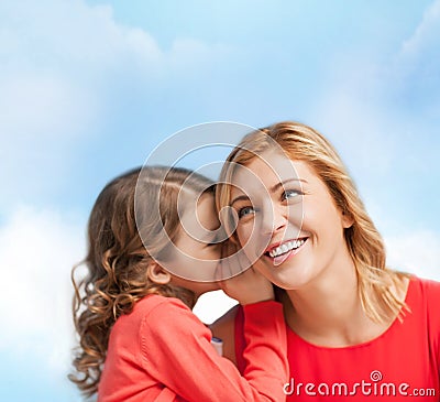 Smiling mother and daughter whispering gossip