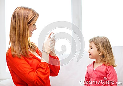 Smiling mother taking picture of daughter