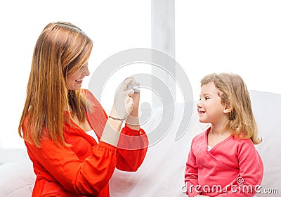 Smiling mother taking picture of daughter