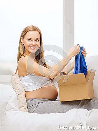 Smiling pregnant woman opening parcel box