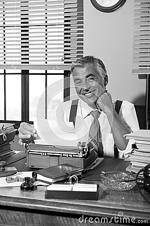 Smiling retro reporter working at office desk