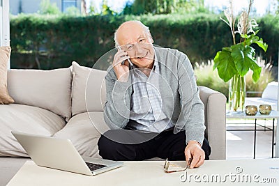 Smiling Senior Man Answering Smartphone At Nursing