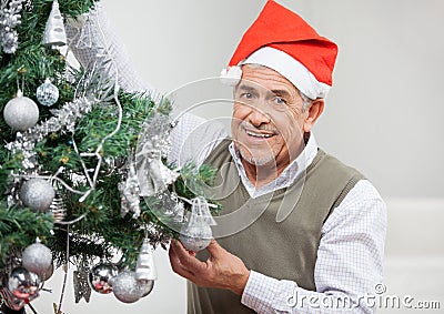 Smiling Senior Man Decorating Christmas Tree