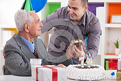 Smiling senior man receiving gift for birthday