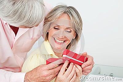 Smiling senior woman receiving gift