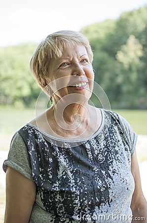 Smiling senior woman walking in the park