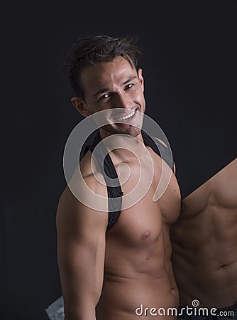 Smiling shirtless man holding mirror