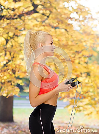 Smiling sporty woman with skipping rope