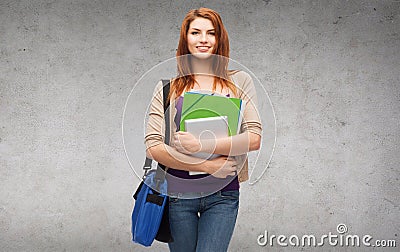 Smiling student with bag, folders and tablet pc