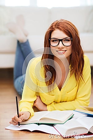 Smiling student girl reading books at home