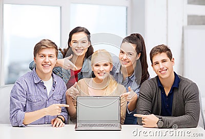 Smiling students pointing to blank lapotop screen