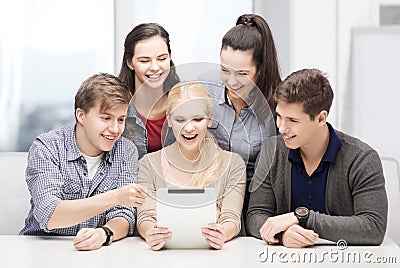 Smiling students with tablet pc at school