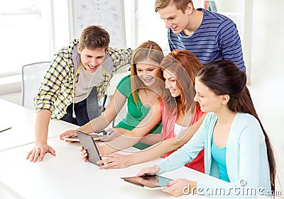 Smiling students with tablet pc at school
