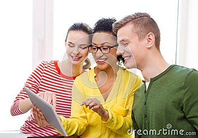 Smiling students with tablet pc at school