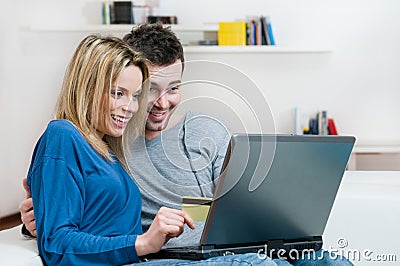 Smiling surprised couple online shopping