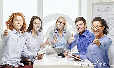Smiling team with table pc and papers working