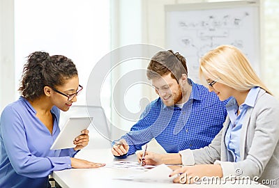 Smiling team with table pc and papers working