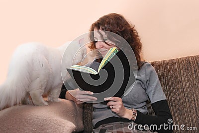 Smiling woman and cat reading book