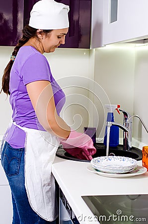 Smiling woman cook cleaning dishes