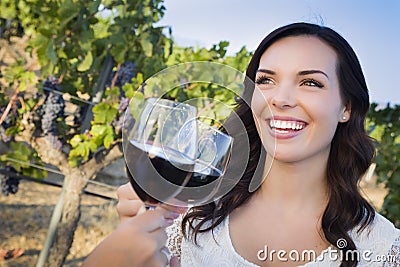 Smiling Woman Enjoying Glass of Wine in Vineyard With Friends