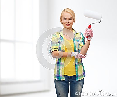 Smiling woman in gloves with paint roller