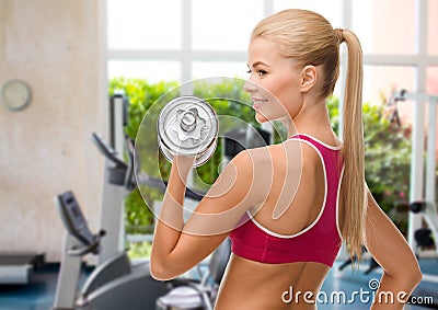 Smiling woman with heavy steel dumbbell