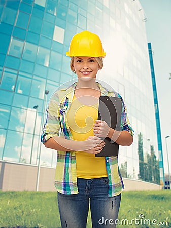 Smiling woman in helmet with clipboard