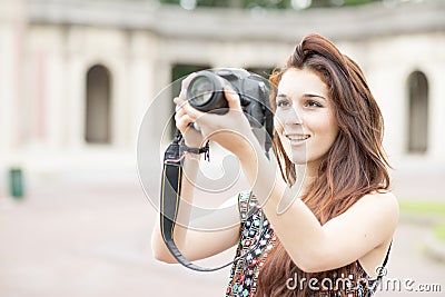Smiling woman holding camera and taking pictures.