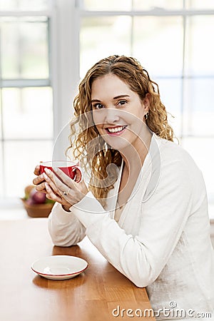 Smiling woman holding red coffee cup