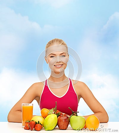 Smiling woman with organic food or fruits on table