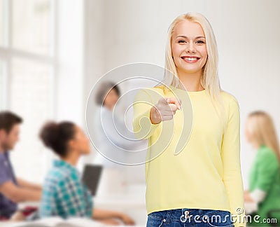Smiling woman pointing finger at you