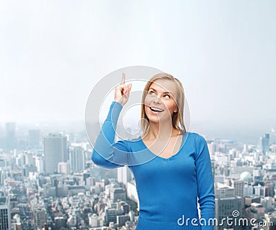 Smiling woman pointing her finger up