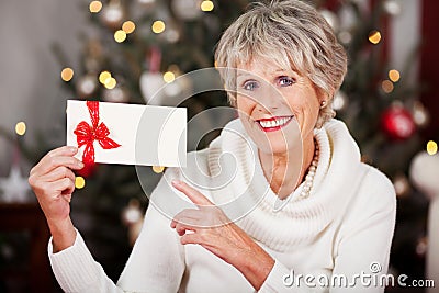 Smiling woman pointing to a Christmas voucher