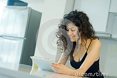 Smiling woman reading on digital tablet