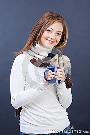 Smiling woman in scarf with cup of tea