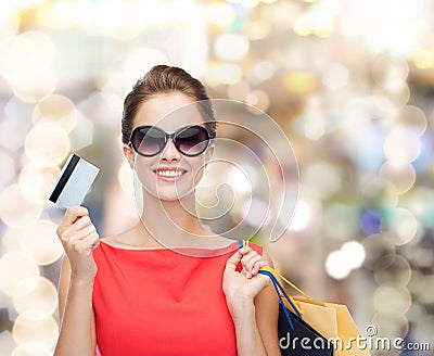 Smiling woman with shopping bags and plastic card